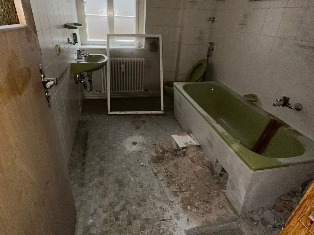 Badezimmer nach Sanierungsarbeiten mit Bauschutt auf dem Boden vor der Grundreinigung Badezimmer nach Sanierungsarbeiten mit Bauschutt auf dem Boden vor der Grundreinigung